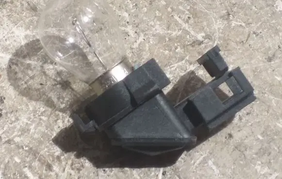 Tail light bulb cover holder