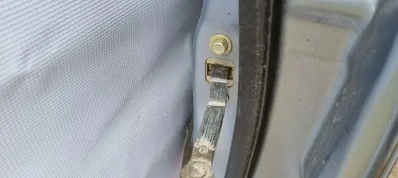 Front door check strap stopper