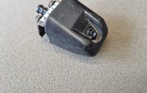 Mitsubishi Pajero Sport I Headlight washer spray nozzle