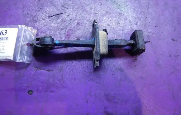 Front door check strap stopper